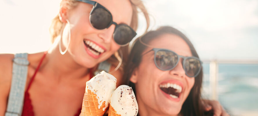 zwei Frauen im Sonnenschein essen Eis in der Tüte